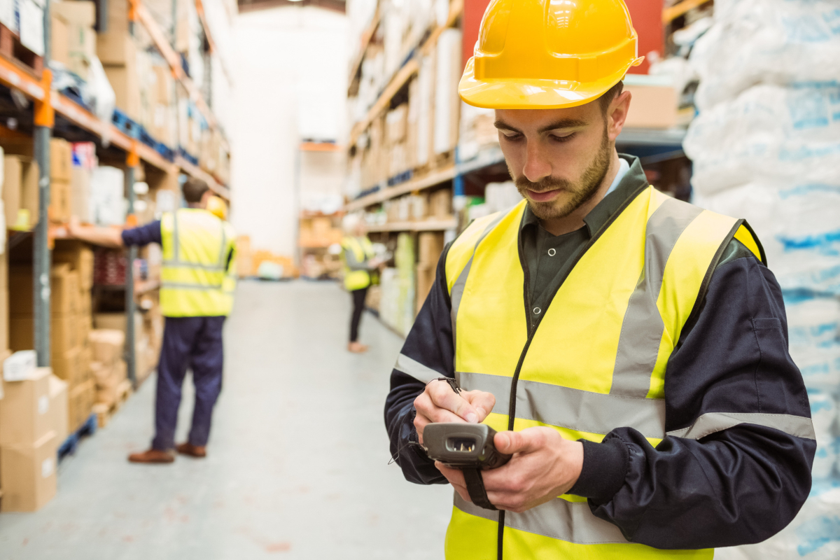 A man in a hard-hat working in a warehouse